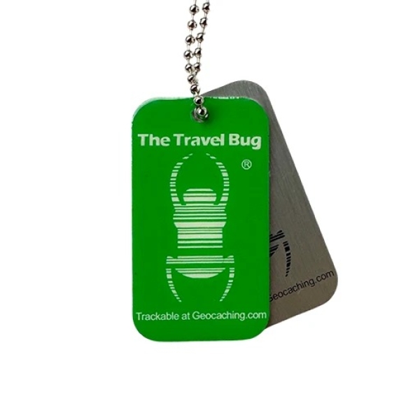 Grüner Geocaching QR Travel Bug® mit Glow-in-the-Dark-Effekt und QR-Code für Trackable-Abenteuer.
